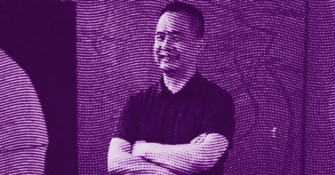 A person with arms crossed stands against a backdrop of wavy, horizontal lines. The image is tinted in purple, with the lines creating an abstract, textured effect over the figure. © Illustration by ArtCritic.