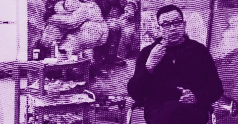 A person sits with legs crossed, holding an object near their mouth, in a room with various items and artwork visible in the background. The image has a purple color filter and a wavy, textured overlay effect. © Illustration by ArtCritic.