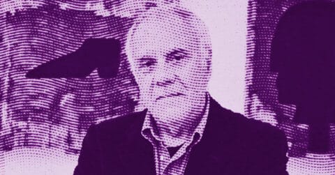 A man in a suit sits in front of abstract artwork, shown in a purple duotone halftone effect that adds a dotted pattern overlay to the entire image. © Illustration by ArtCritic.