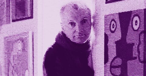 A stylized, purple-tinted halftone image of a person with short hair, wearing a scarf, standing indoors next to a wall with framed artwork. The person is looking toward the camera. © Illustration by ArtCritic.