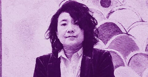 A person with wavy, shoulder-length hair wearing a collared shirt and jacket stands in front of a wall with overlapping circular patterns. The image has a purple tint and a halftone effect. © Illustration by ArtCritic.