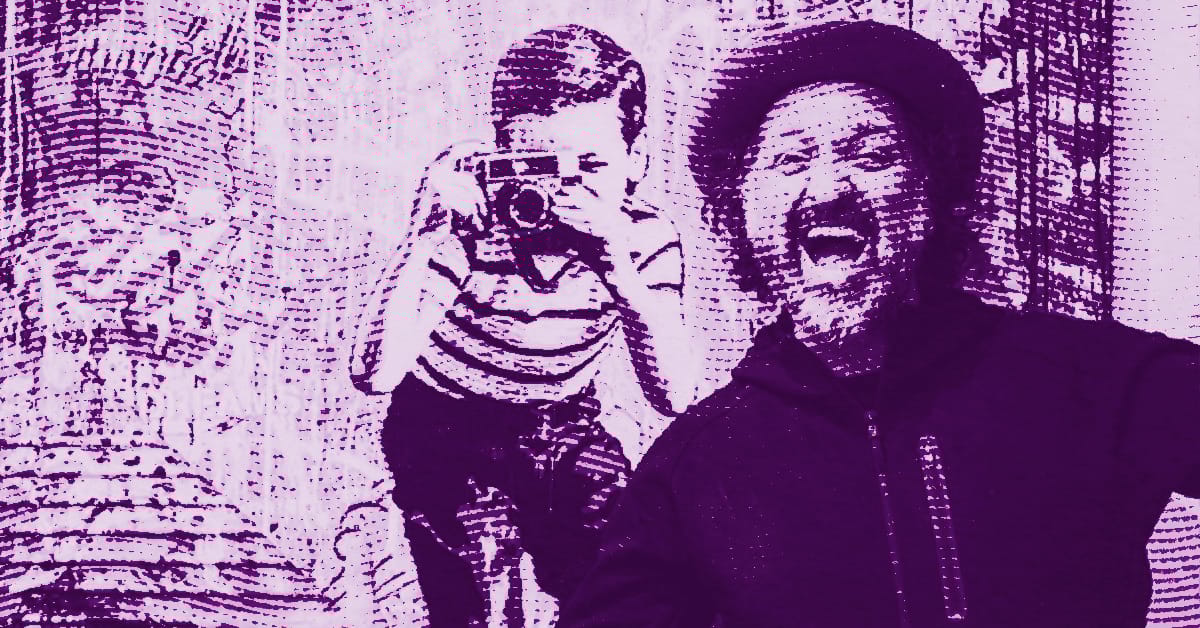 A man in a hat smiles widely in the foreground while a boy in the background takes a photo with a camera. The image has a purple color filter and a textured, dotted effect. © Illustration by ArtCritic.