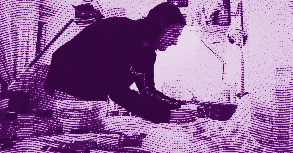 Tony Tafuro leans over a table, working intently with papers or objects. The image is filtered in shades of purple and features a wavy, dotted texture effect throughout. © Illustration by ArtCritic.