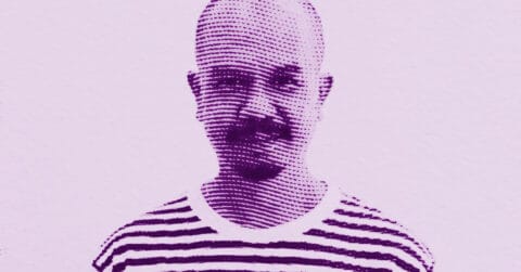 A stylized, purple-toned halftone image of Kitti Narod with a bald head, mustache, and goatee, wearing a striped shirt, smiling against a plain light background. © Illustration by Art Critic.