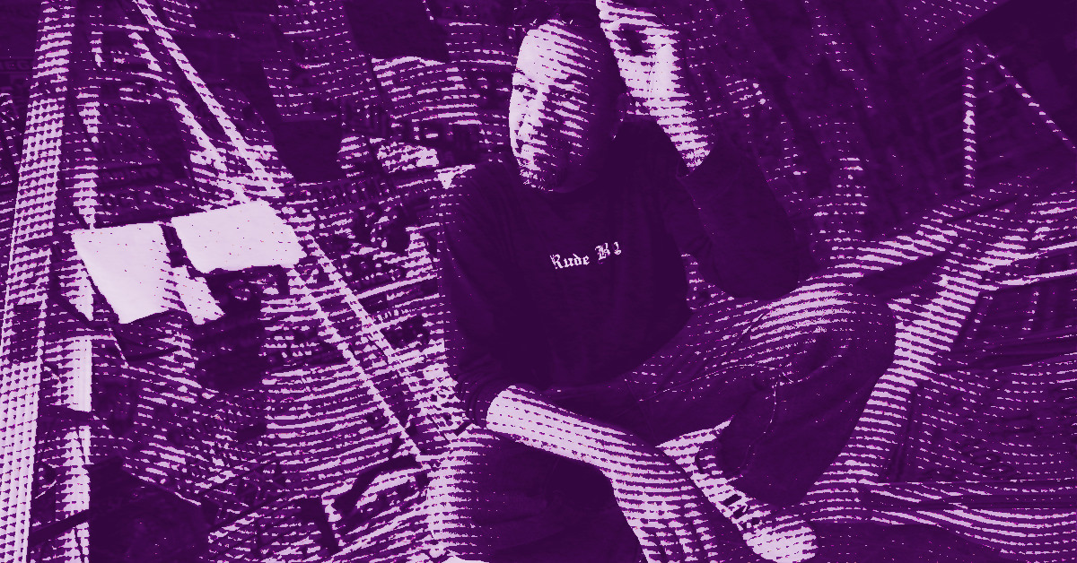 Gary Simmons sits on the floor surrounded by scattered papers, holding a pen near his head. The image is filtered with a purple halftone effect, creating a stylized, textured appearance. © Illustration by Art Critic.