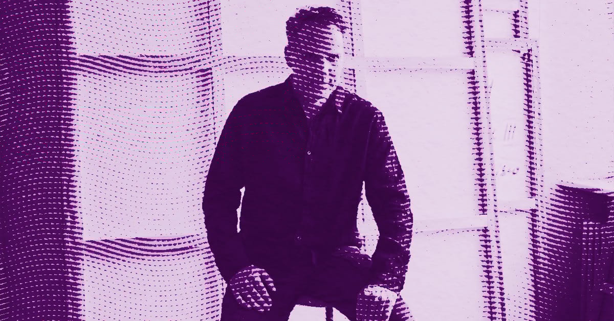 Andy Denzler in a dark shirt sits on a stool in a room with large windows, shown in a purple halftone effect. © Illustration by Art Critic.