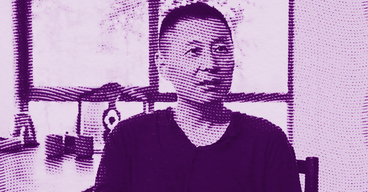 Geng Jianyi sits indoors in front of a window and workshop items, facing slightly to the side. The image has a purple color filter and a halftone dot effect. © Illustration by Art Critic.