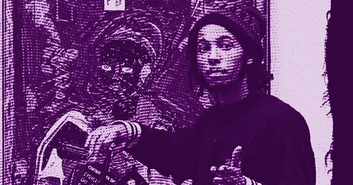 Alexandre Diop in a beanie stands beside a detailed, abstract painting featuring a face with bright eyes. The image has a purple tint and a textured, halftone effect. The person gestures towards the artwork. © Illustration by Art Critic.